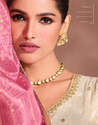 Maharani Royal Couture cream Anarkali gown with embroidered neckline and sleeves, paired with a pink Bandhani dupatta.