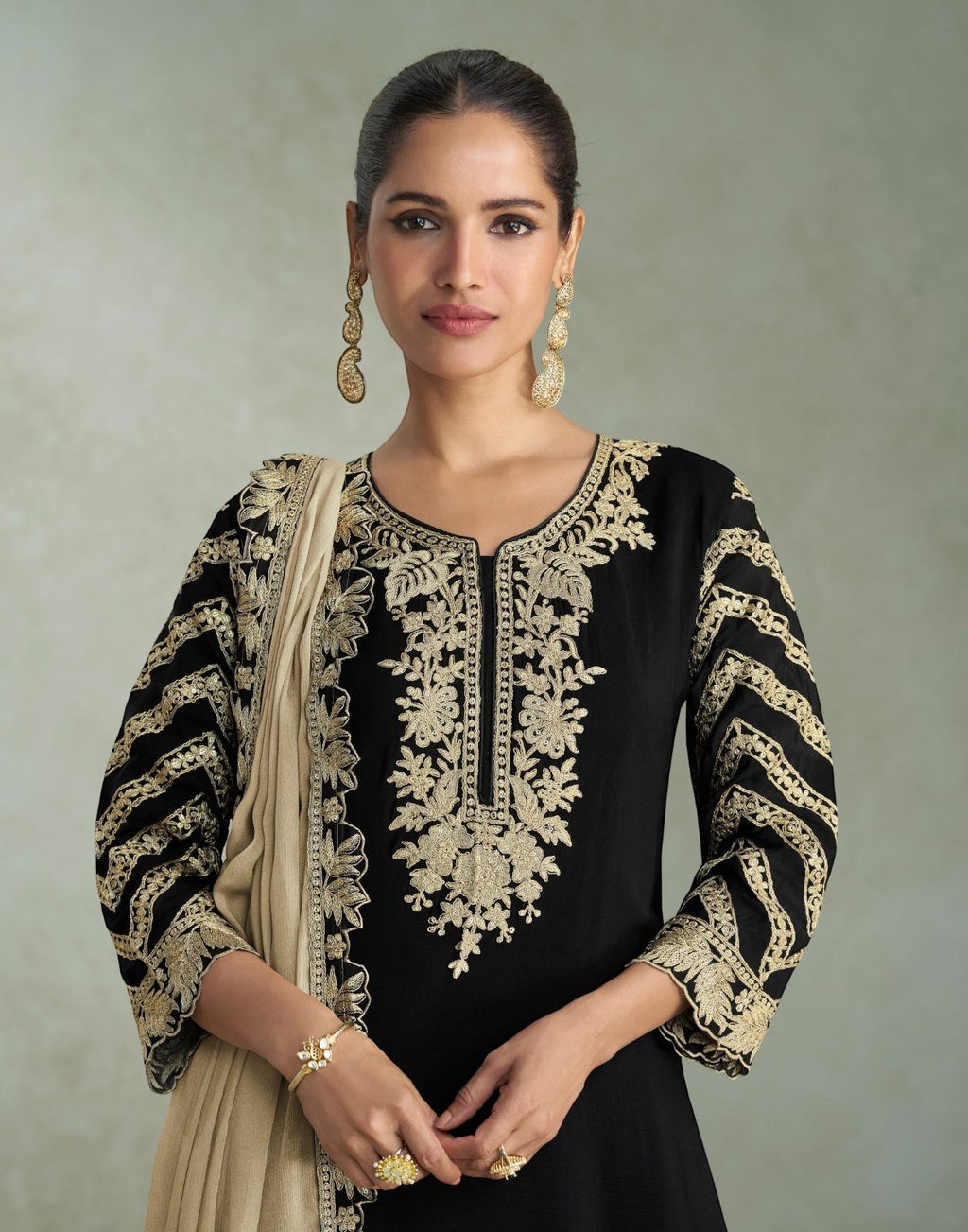 Maharani Royal Couture black chinon silk suit with heavy gold embroidery on neckline, sleeves, and dupatta. Beige dupatta draped.
