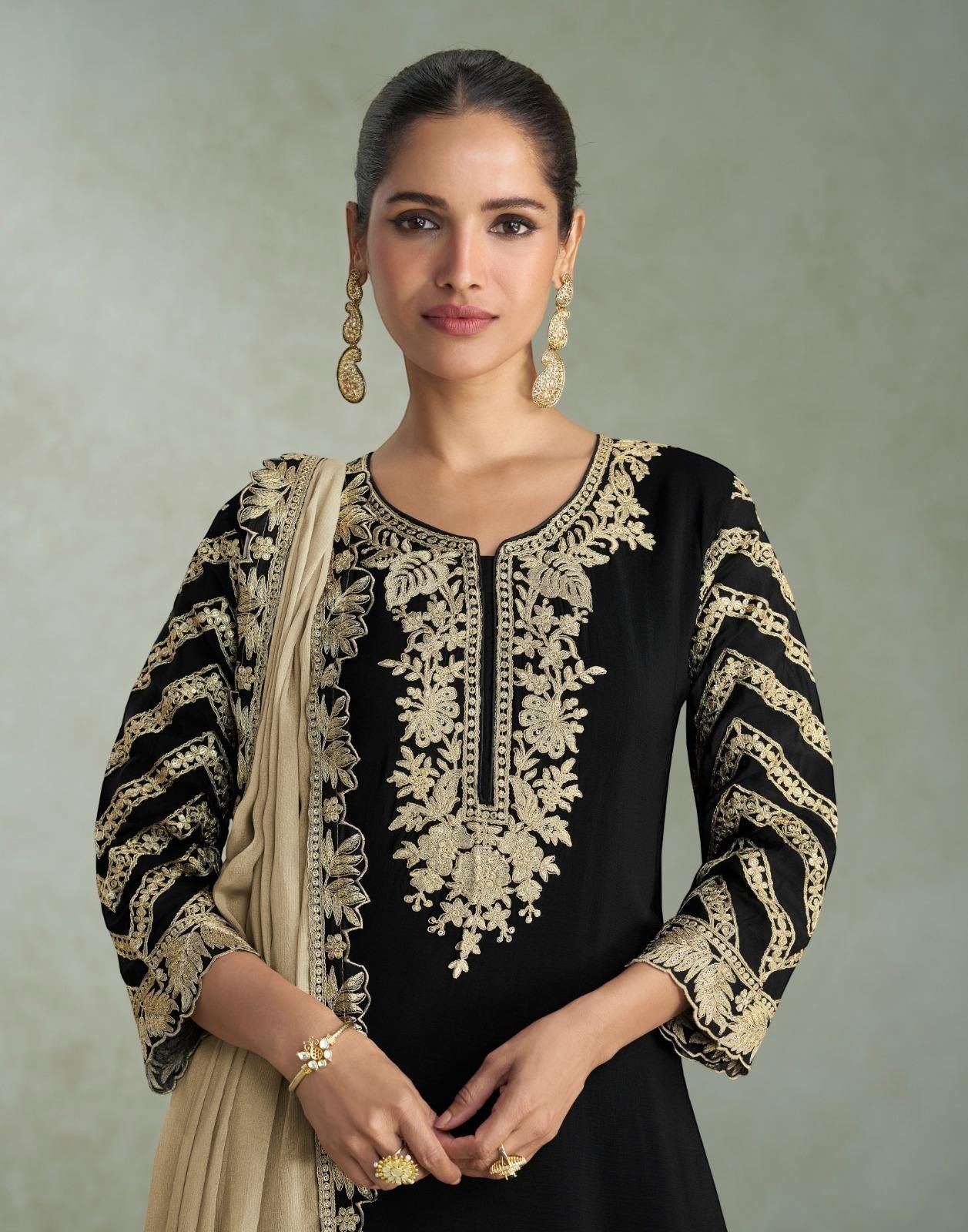 Maharani Royal Couture black chinon silk suit with heavy gold embroidery on neckline, sleeves, and dupatta. Beige dupatta draped.