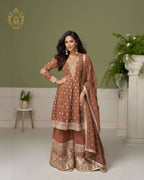 Maharani Royal Couture brown georgette suit with hand embroidery on neckline, sleeves, and hem, paired with heavily embroidered sharara pants and dupatta.