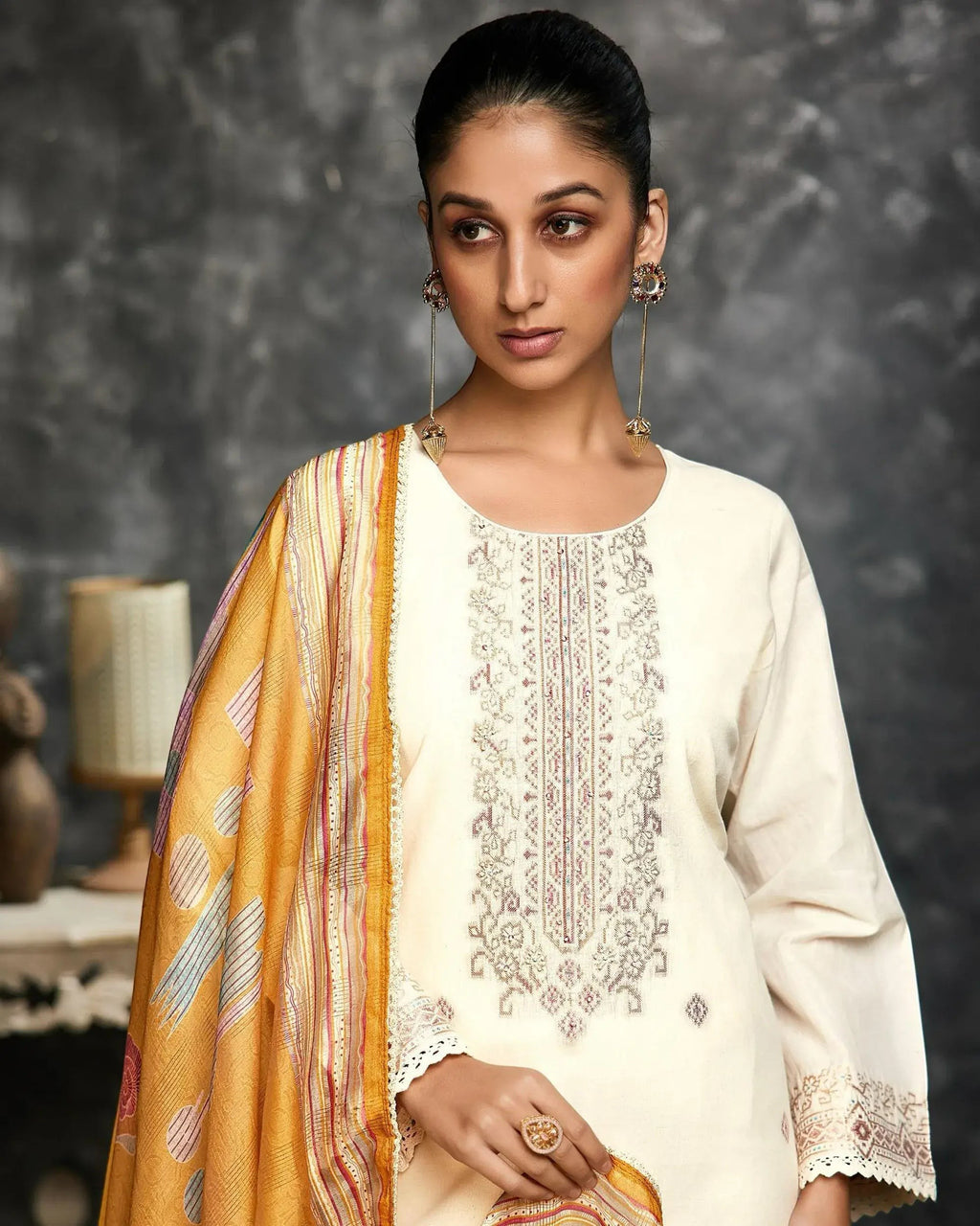 Maharani Royal Couture cream lawn cotton suit with intricate handwork embroidery on the neckline and lace border on sleeves and hem. Paired with a yellow digital print dupatta.