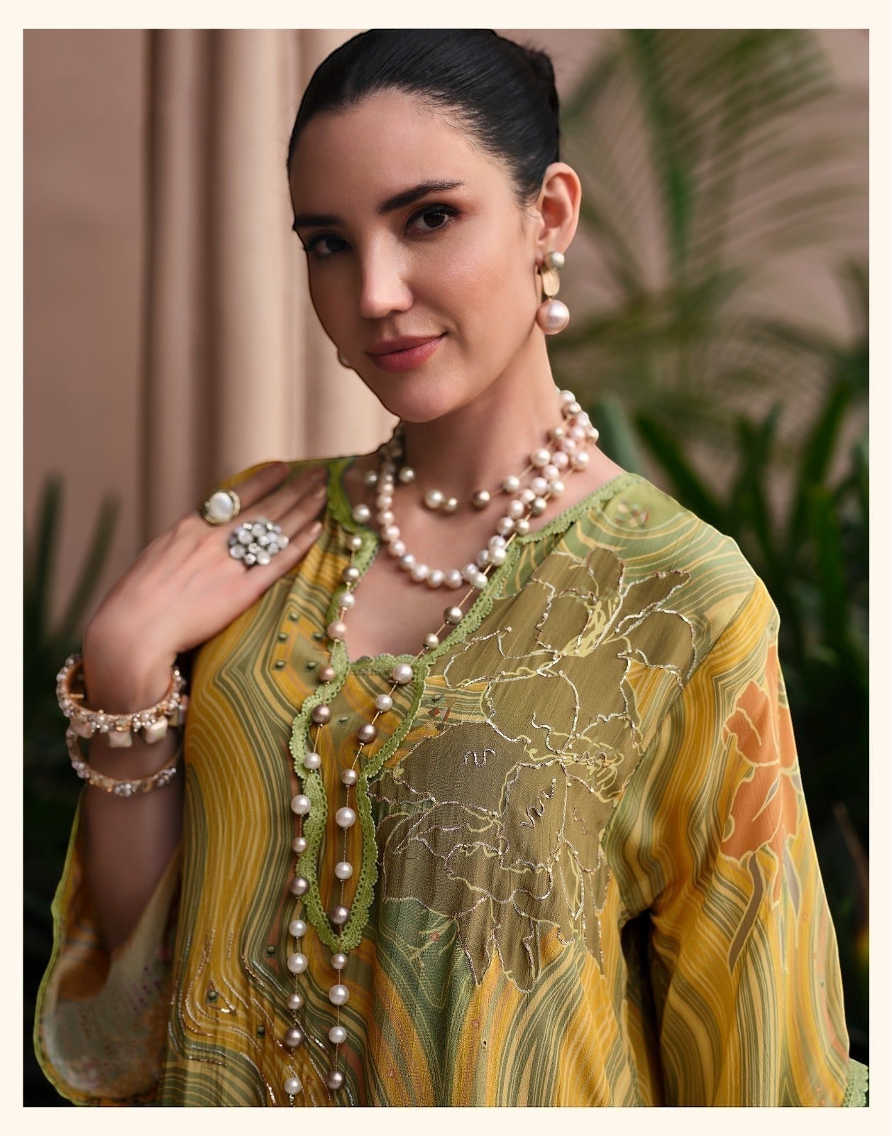 Maharani Royal Couture yellow and green mul cotton suit with digital print, dabka work, and lace trim. Model wears pearl jewelry.