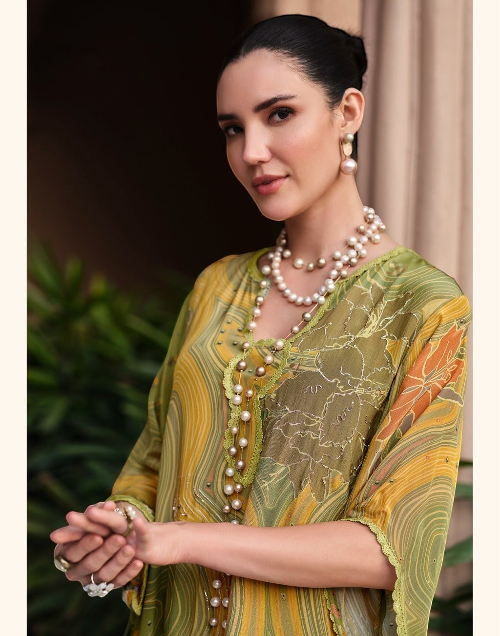Maharani Royal Couture green and yellow mul cotton suit with digital print, dabka work, and lace finish. Model wears pearl necklace.