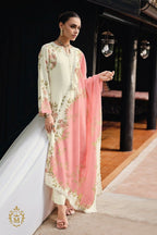 Maharani Royal Couture cream viscose muslin suit with digital floral print, handwork, lace trim, and pink dupatta. Model wears cream pants and pink heels.